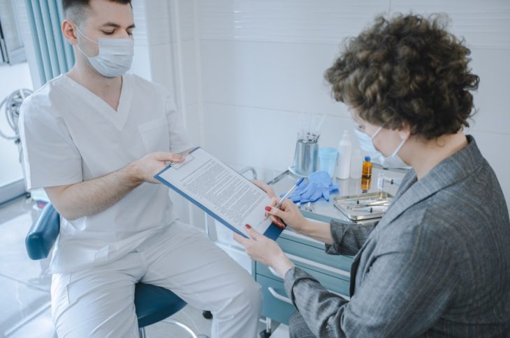 patient sign a form in a doctors office