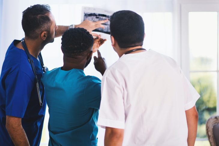 three doctors looking at an mri