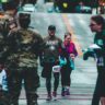 man walking down the street in a army t-shirt