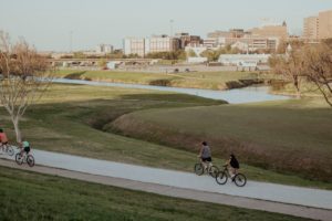 two people riding a bicycle in a Texas park